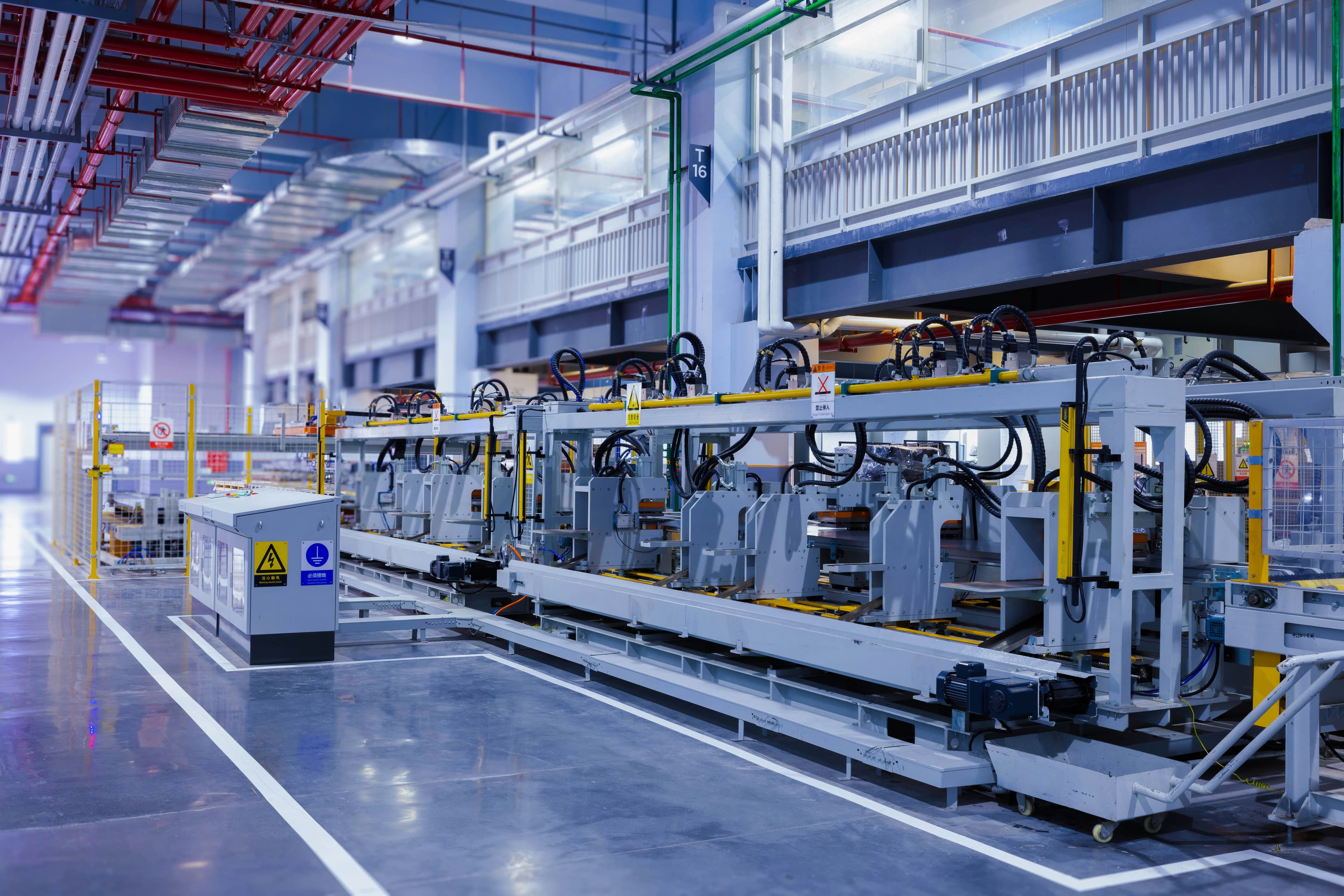 Industrial manufacturing production line with automated machinery and robotic systems for predictive maintenance monitoring